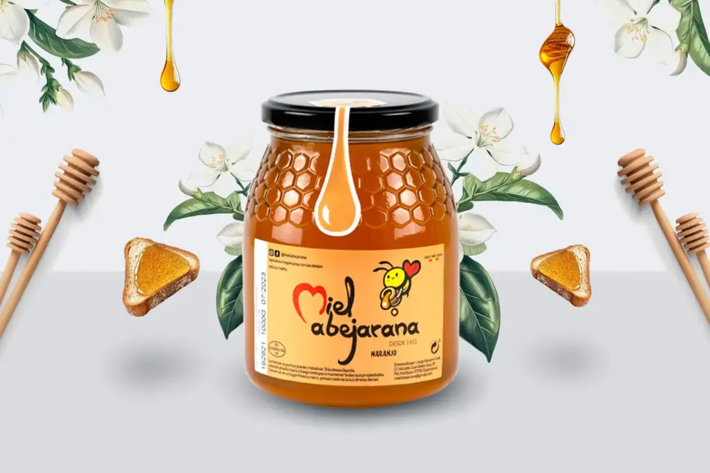 Frasco de miel de azahar (de naranjo) Miel Abejarana acompañado de flores de azahar, tostadas con miel y cucharas de madera, sobre fondo claro.