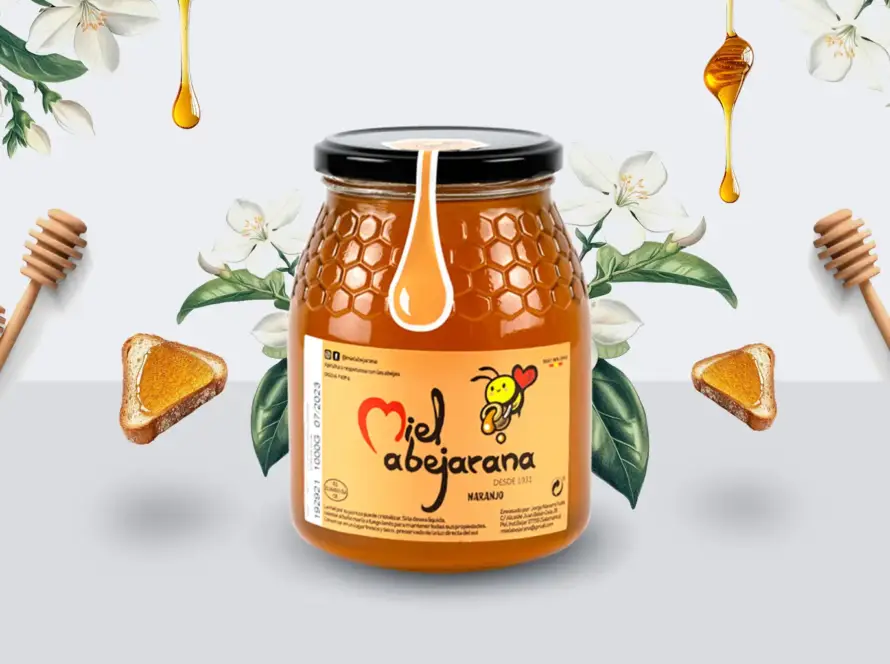 Frasco de miel de azahar (de naranjo) Miel Abejarana acompañado de flores de azahar, tostadas con miel y cucharas de madera, sobre fondo claro.